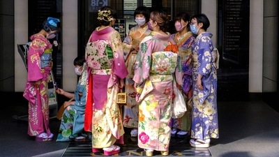 Women clad in a tradition Japanese kimonos are pictured standing by a building's entrance during the "golden week" holiday in Tokyo (Photo by Charly TRIBALLEAU / AFP) Women clad in a tradition Japanese kimonos are pictured standing by a building's entrance during the "golden week" holiday in Tokyo (Photo by Charly TRIBALLEAU / AFP)