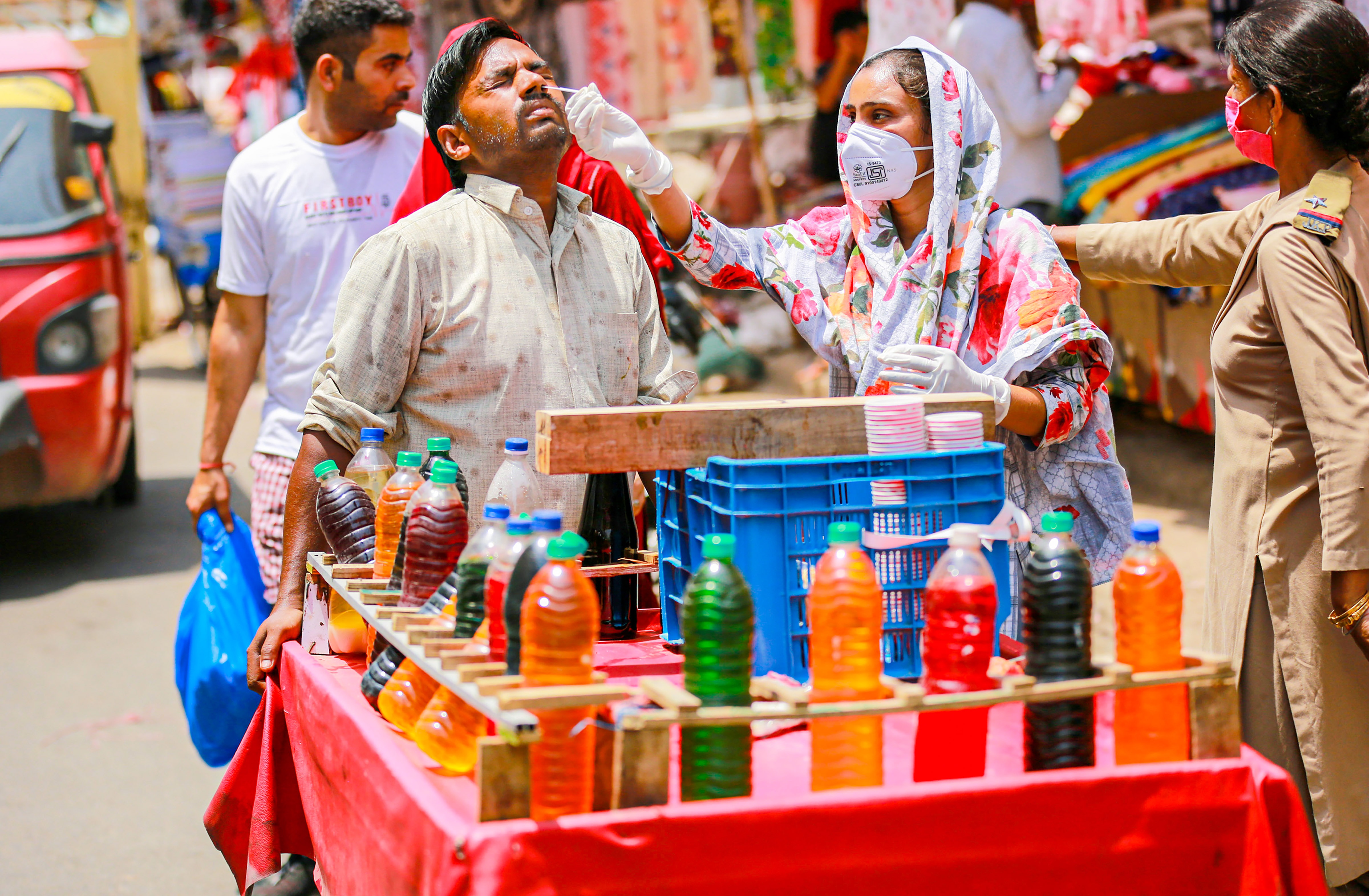 A healthcare worker collects swab sample of a vendor for Covid-19 testing in Jammu. (PTI) A healthcare worker collects swab sample of a vendor for Covid-19 testing in Jammu. (PTI)