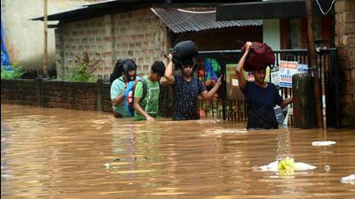Guwahati: Commuters wade through a waterlogged area following heavy rains on Tuesday (ANI)