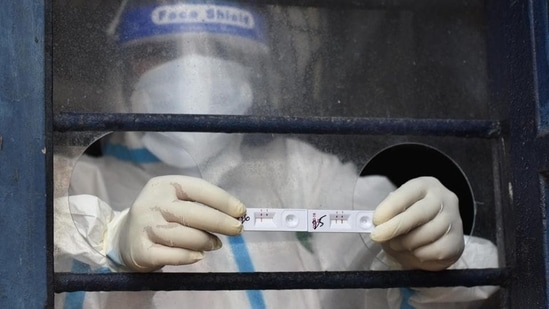 A medical professional shows COVID-19 test results conducted at Gandhi Nagar in New Delhi. (Sonu Mehta / HT Photo)