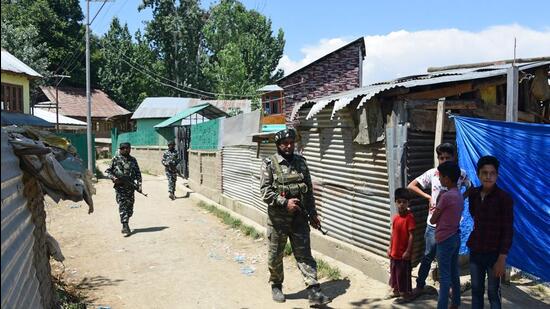 Security personnel stand guard during an encounter in Kulgam district of south Kashmir on Tuesday. Security forces gunned down two LeT militants in Shopian in the morning, including the killer of bank manager Vijay Kumar. (Waseem Andrabi/HT)
