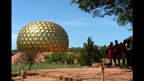 Visitors stand near the Matri Mandir, an edifice of spiritual significance for practitioners of integral yoga, in Auroville near Pondicherry on April 9, 2022. (Photo by Arun SANKAR / AFP) (AFP)