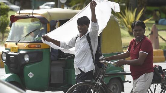 A commuter shields himself from the scorching heat on a hot summer afternoon in New Delhi. (HT Photo)
