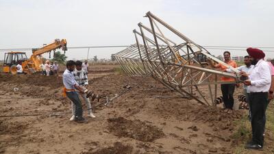 PSPCL officials and workers working on repairing the power towers that collapsed at Badi village near Airport Road in Mohali following strong winds. (Sanjeev Sharma/HT)