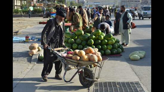 A vendor pushes a wheelbarrow loaded with melons at a market in Kabul on June 15, 2022 (AFP)