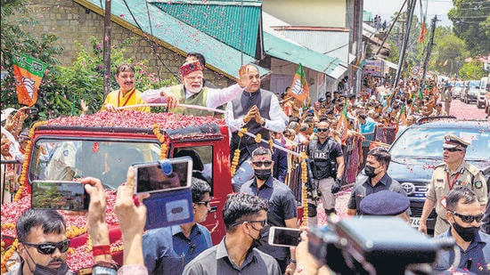 Prime Minister Narendra Modi waves at BJP workers during a roadshow in Dharamshala on Thursday. (PTI)