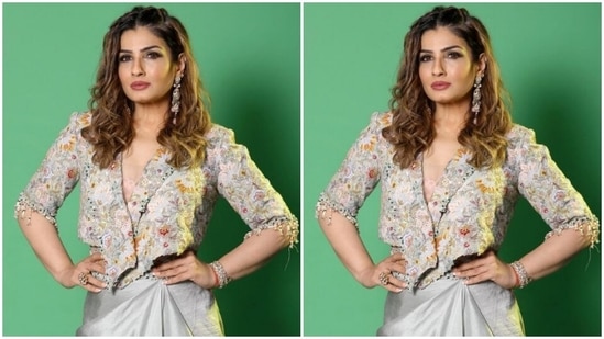 Raveena paired a heavily embellished grey cropped jacket with a plunging neckline and a grey satin skirt which featured a belt detail in embellishments.(Instagram/@officialraveenatandon)