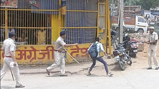 Policemen chasing away a youngster protesting against the Agnipath recruitment scheme in Rewari on Thursday. (Ht Photo)