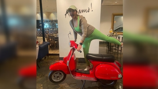 Huma Qureshi gets captured while goofing around. In this photo, the actor can be seen getting on a red vintage with a funny expression.(Instagram/@iamhumaq)