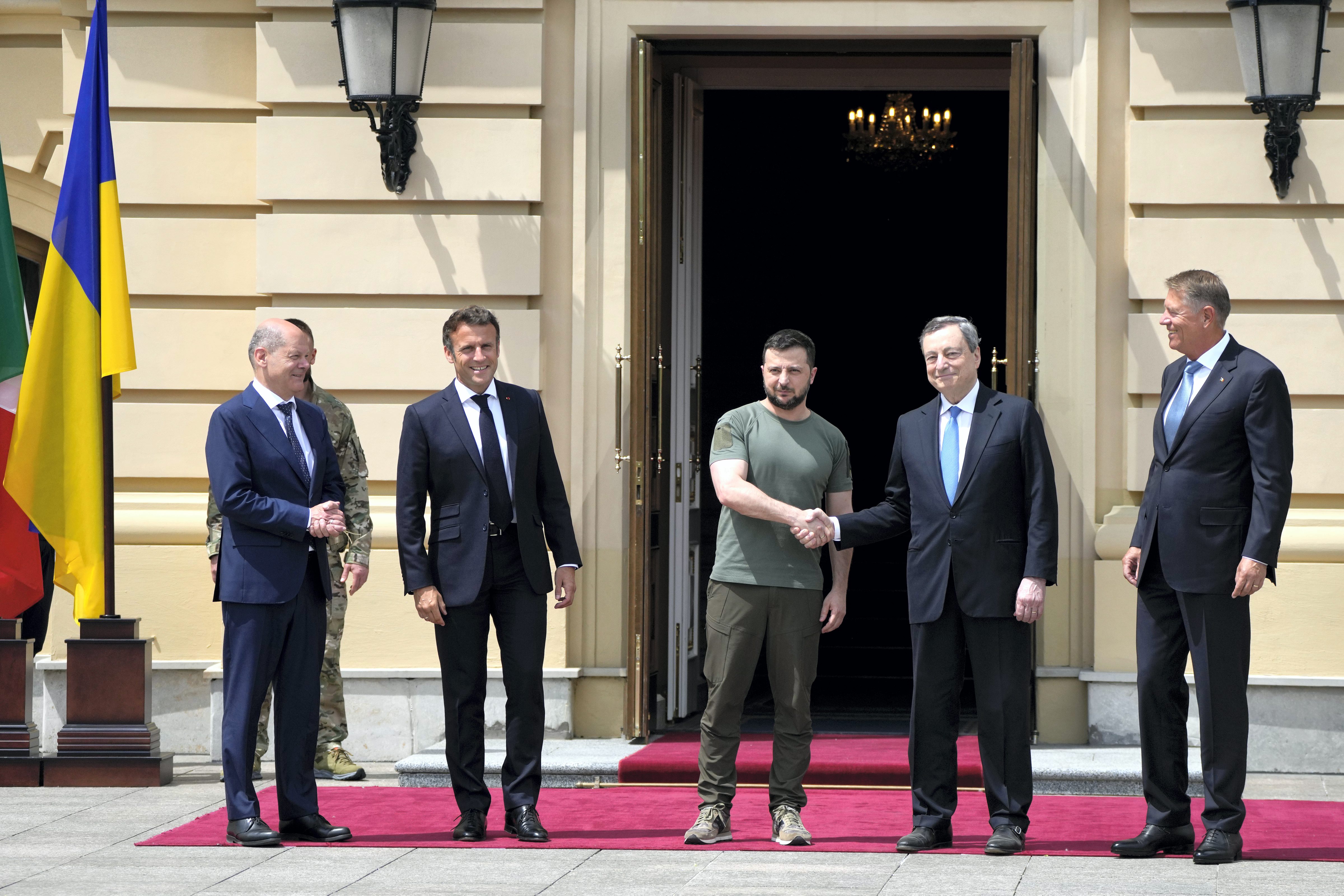 Ukrainian President Volodymyr Zelenskyy, center, and Italian Prime Minister Mario Draghi, second right, shake hands as German Chancellor Olaf Scholz, left, France's President Emmanuel Macron, second left, and Romanian President Klaus Iohannis stand beside at the Mariyinsky Palace in Kyiv, Ukraine, Thursday, June 16, 2022. &nbsp; (AP)