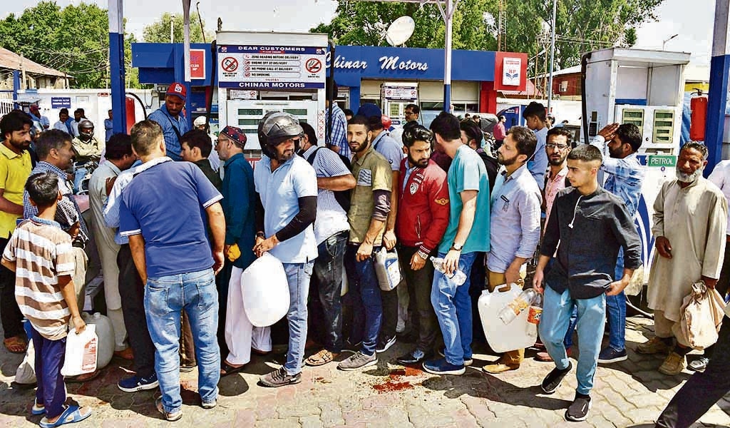 People arrive at a petrol station with empty containers amid a fuel shortage, in Srinagar on Thursday. (ANI)