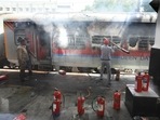 Railway officials douse a fire in a railway coach at a Secundrabad railroad station in Hyderabad. Railway officials douse a fire in a railway coach at a Secundrabad railroad station in Hyderabad.