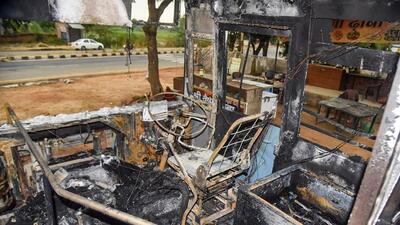 A bus that was torched by protestors in Aligarh’s Tappal area during the agitation against the Agnipath scheme on Friday. (PTI PHOTO)