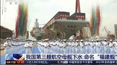 In this image taken from video footage run by China's CCTV, sailors applaud as China's third aircraft carrier christened Fujian is launched at a dry dock in Shanghai on Friday, June 17, 2022. State media reported that China on Friday launched its third aircraft carrier, the first such ship to be both designed and built entirely within the country. Chinese characters on screen reads "Our country's third aircraft carrier launched into water, named Fujian”. (AP)