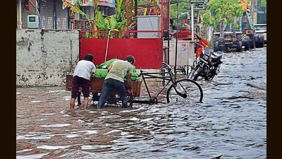 Cart-pullers try to make their way out of an inundated road in Ludhiana on Friday. (Harvinder Singh/HT)