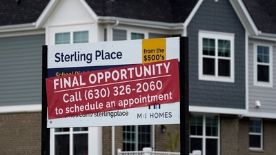 An advertising sign for building land stands in front of a new home construction site in Northbrook, Ill.. Record low-interest mortgages are long gone. Credit card rates will likely rise. You'll pay more for an auto loan. (AP)
