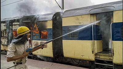 A train set on fire by people protesting against the Centre's Agnipath scheme, in Bhojpur on Friday. (PTI)