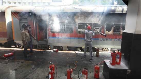 Railway officials douse a fire in a railway coach at a Secundrabad railroad station in Hyderabad.(AP)