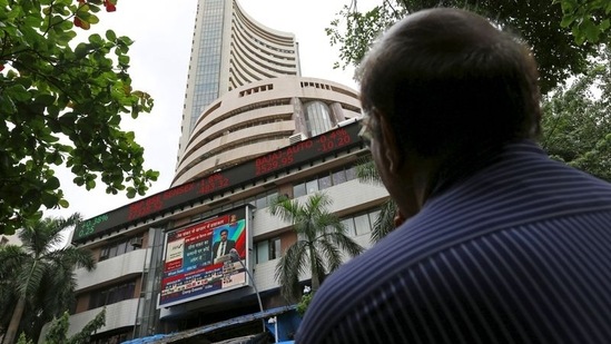 A man looks at a screen across a road displaying the Sensex on the facade of the Bombay Stock Exchange (BSE) building in Mumbai.(Reuters)