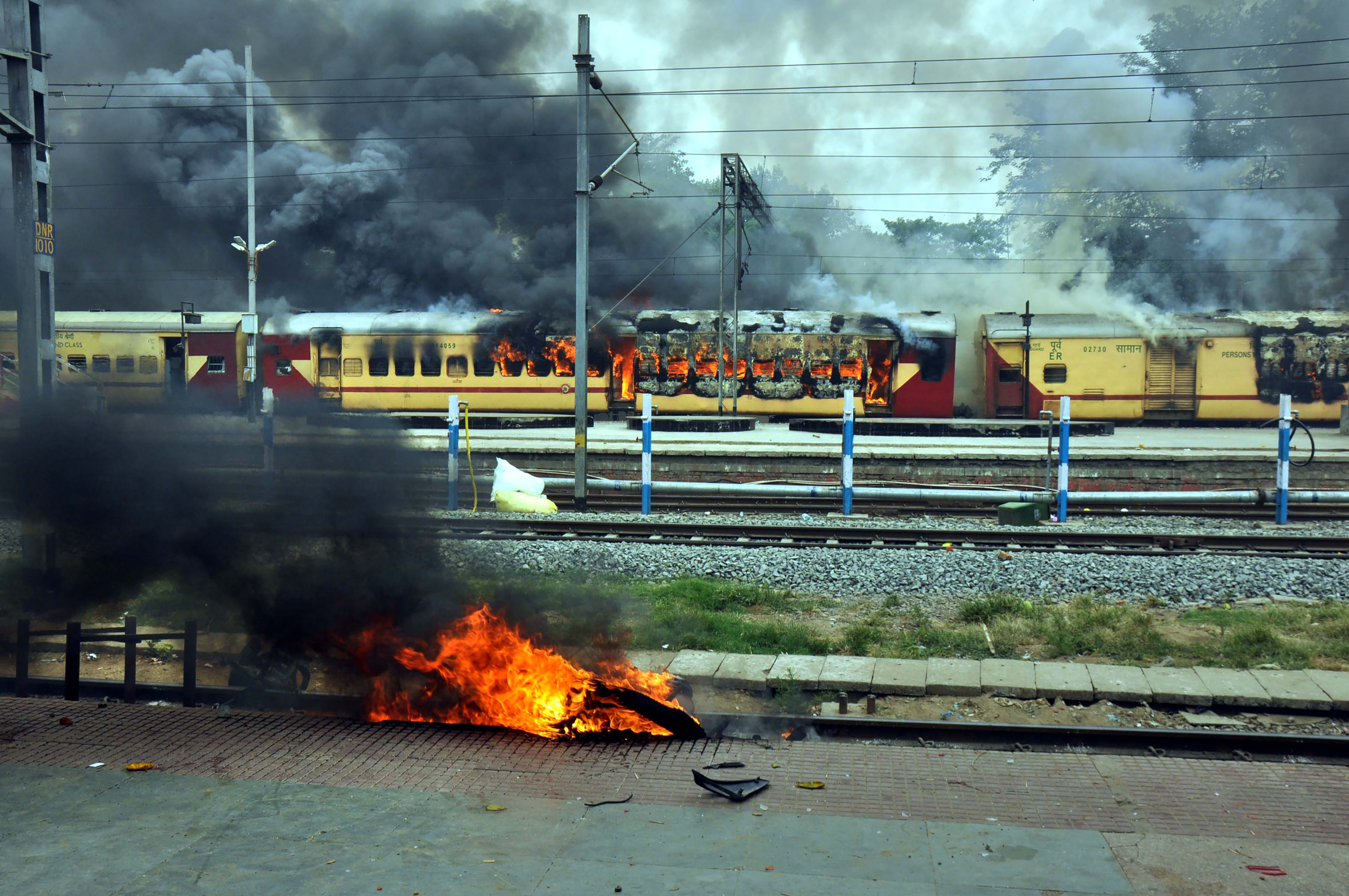 A train set on fire by a crowd against the Centre’s Agnipath at Danapur railway station. (PTI)