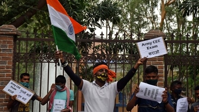 An Army aspirant holds a national flag and a placard during a protest against the Agnipath Recruitment Scheme for the Armed Forces, at Raj Bhawan, in Ranchi on Saturday. (ANI) An Army aspirant holds a national flag and a placard during a protest against the Agnipath Recruitment Scheme for the Armed Forces, at Raj Bhawan, in Ranchi on Saturday. (ANI)