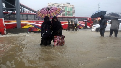 People wade through flooded waters in Sylhet, Bangladesh. (AP) People wade through flooded waters in Sylhet, Bangladesh. (AP)