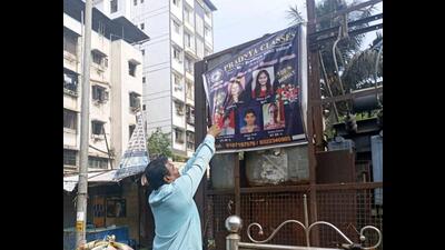 A Kalyan Dombivli Municipal Corporation staff removing illegal banners and hoardings. (HT PHOTO)