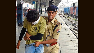 Police constraining a member of the mob during a violent protest against Agnipath scheme in Ludhiana on Saturday. (Gurpreet Singh/HT)