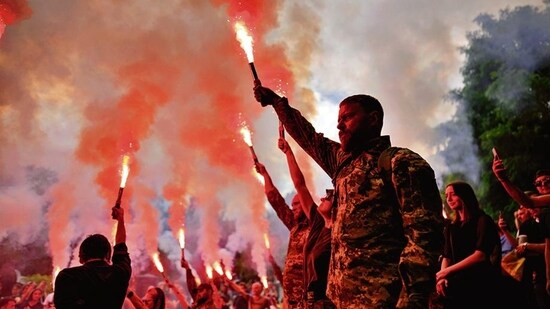 Soldiers hold flares as they attend the funeral of activist and soldier Roman Ratushnyi in Kyiv, Ukraine, on Saturday.&nbsp;(AP)