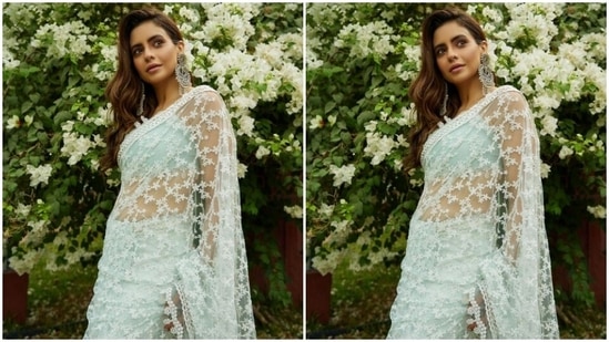 Aamna teamed a pastel blue sleeveless blouse with a translucent white saree with floral details in white threads. In statement oxidised earrings, bracelets and bangles, she completed her look.(Instagram/@aamnasharifofficial)