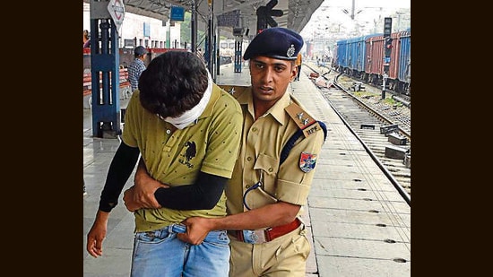 Police constraining a member of the mob during a violent protest against Agnipath scheme in Ludhiana on Saturday. (Gurpreet Singh/HT)