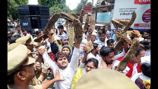 Police personnel stop Aam Aadmi Party (AAP) supporters during the protest against the Gobardhan Scheme and Agnipath scheme, at the district collectorate office, in Lucknow on Saturday. (ANI)