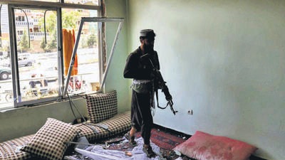 A Taliban fighter walks into a house damaged in the blast, in Kabul on Saturday. (Reuters)