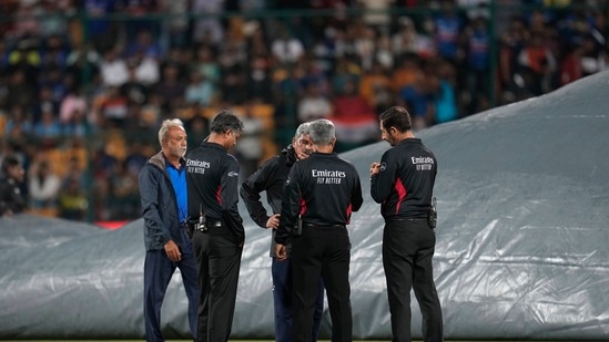 Officials inspect the ground after rains delay the start of the fifth Twenty20 cricket match between Indian and South Africa(AP)