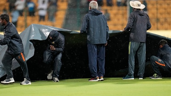 Groundsmen cover the pitch as it rains during the fifth Twenty20 cricket match between Indian and South Africa(AP)