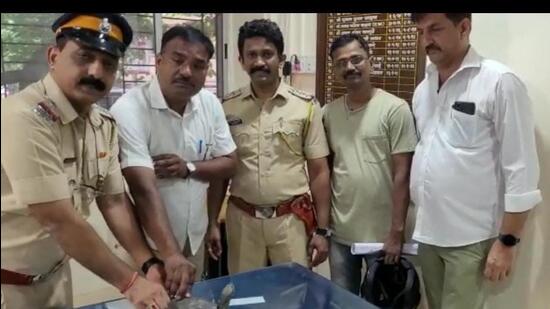 (Left) Sudhir Kudalkar with a forest official (in white) and Santosh Matlani (right) with the rescued turtle. (HT Photo)