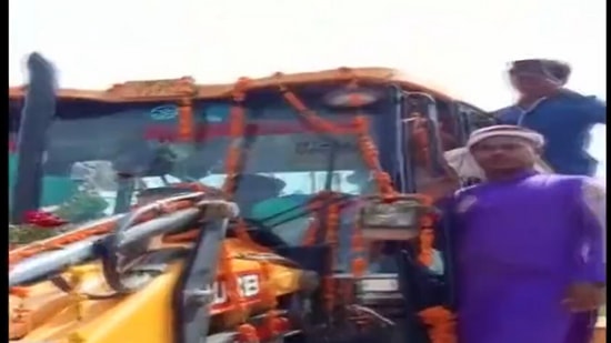 People seen hanging from the bulldozer as the groom rides the machine to reach his wedding venue in Uttar Pradesh. (Screengrab.ANI video)