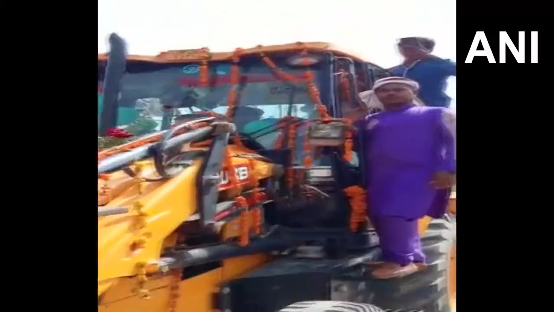 People seen hanging from the bulldozer as the groom rides the machine to reach his wedding venue in Uttar Pradesh. (Screengrab.ANI video) People seen hanging from the bulldozer as the groom rides the machine to reach his wedding venue in Uttar Pradesh. (Screengrab.ANI video)
