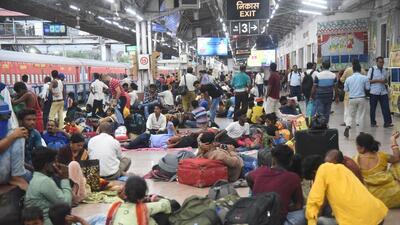 Passengers wait for their train at Patna railway station, following the resumption of train services after being cancelled due to protests against Centre's Agnipath scheme, in Patna on Tuesday. (PTI)