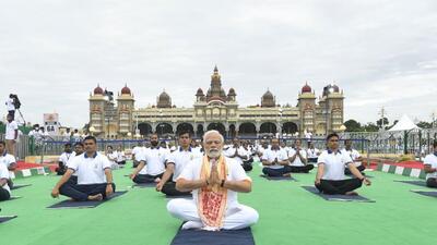 Prime Minister Narendra Modi practices yoga in front of the Mysuru Palace along with thousands of people on Tuesday. (Twitter Photo)