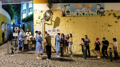 People queue for mass coronavirus disease (Covid-19) testing in Macau, China. (REUTERS)