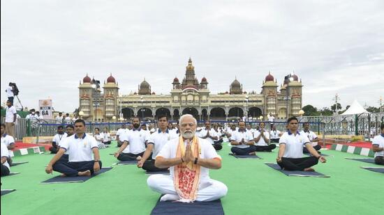Prime Minister Narendra Modi practices yoga in front of the Mysuru Palace along with thousands of people on Tuesday. (Twitter Photo)