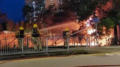 Emergency services personnel work to control fire from a cable transmission bridge that caused a large-scale electrical outage in Yuen Long district of Hong Kong, China. ( REUTERS)