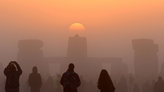 The crowds raised their arms in the air and cheered as the sun rose over the horizon.(AFP)