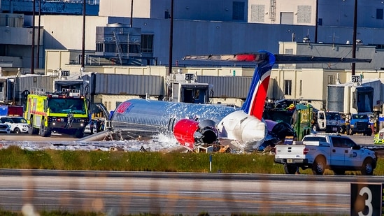 Firefighting units are seen next to a Red Air plane that caught fire after the front landing gear collapsed upon landing at Miami International Airport in Miami, after arriving from Santo Domingo, Dominican Republic, Tuesday, June 21, 2022. (Pedro Portal/Miami Herald via AP)