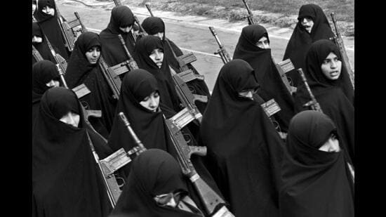 Basiji (mobilized volunteer force) women carrying G-3 automatic assault rifles march in a Tehran rally on 12 February 1987 towards the end of the eight year long Iran-Iraq war. (Kaveh Kazemi/Getty Images)