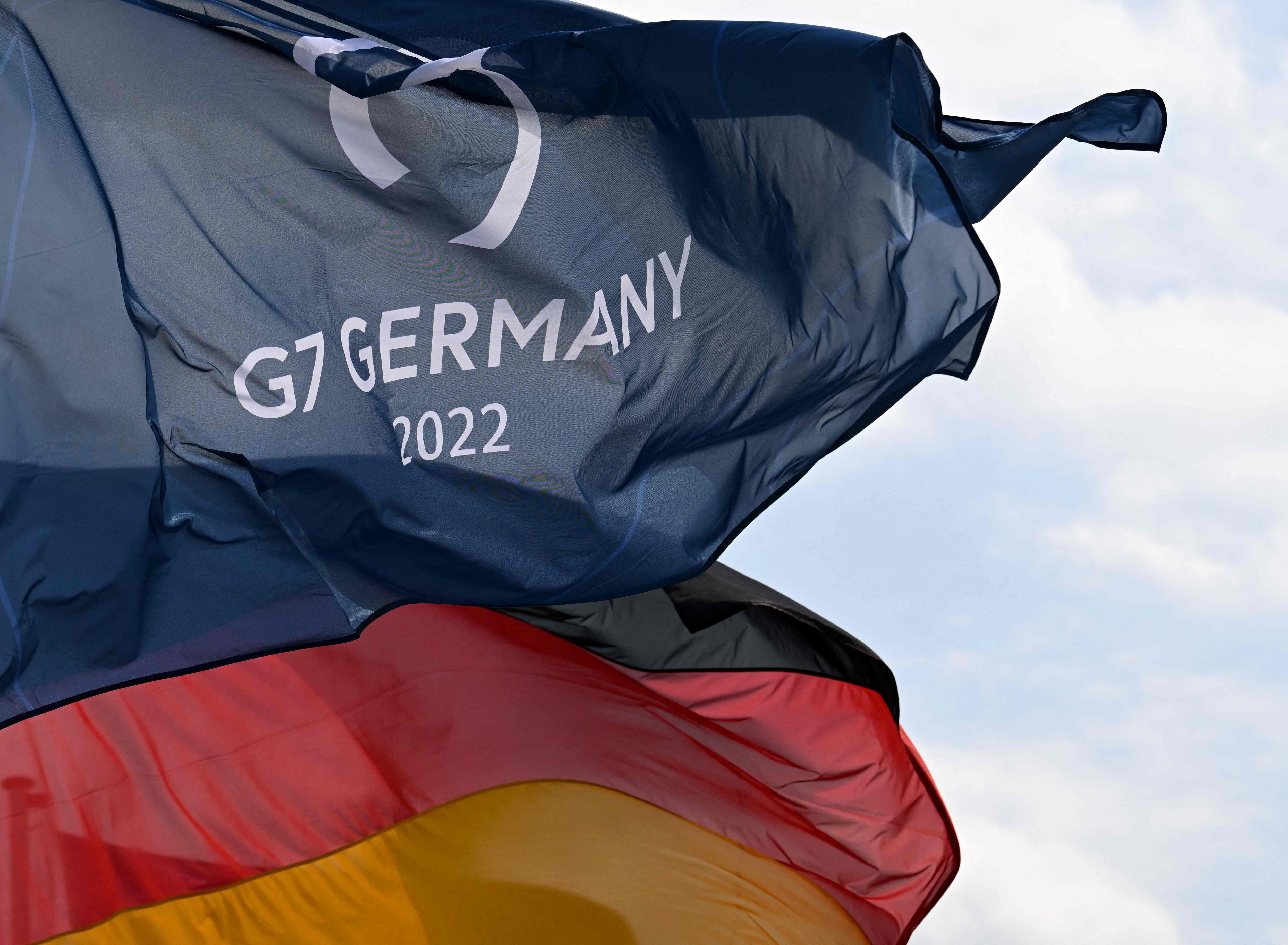 A German national flag and a flag for the G7 Summit fly in the wind in Garmisch-Partenkirchen, southern Germany on June 20, 2022, a few days ahead of the start of the G7 Summit in Elmau. (AFP)