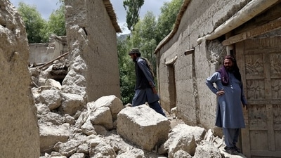 Afghan men stand on the debris of their house that was damaged by an earthquake in Gayan, Afghanistan, June 23, 2022. (REUTERS/Ali Khara) (REUTERS)