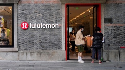 A staff member holds a thermometer to measure the temperature of a customer at an entrance to a Lululemon store, following the coronavirus disease (COVID-19) outbreak in Shanghai. (REUTERS)