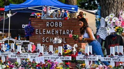 A girl lays flowers at a makeshift memorial at Robb Elementary School in Uvalde, Texas. (AFP) A girl lays flowers at a makeshift memorial at Robb Elementary School in Uvalde, Texas. (AFP)